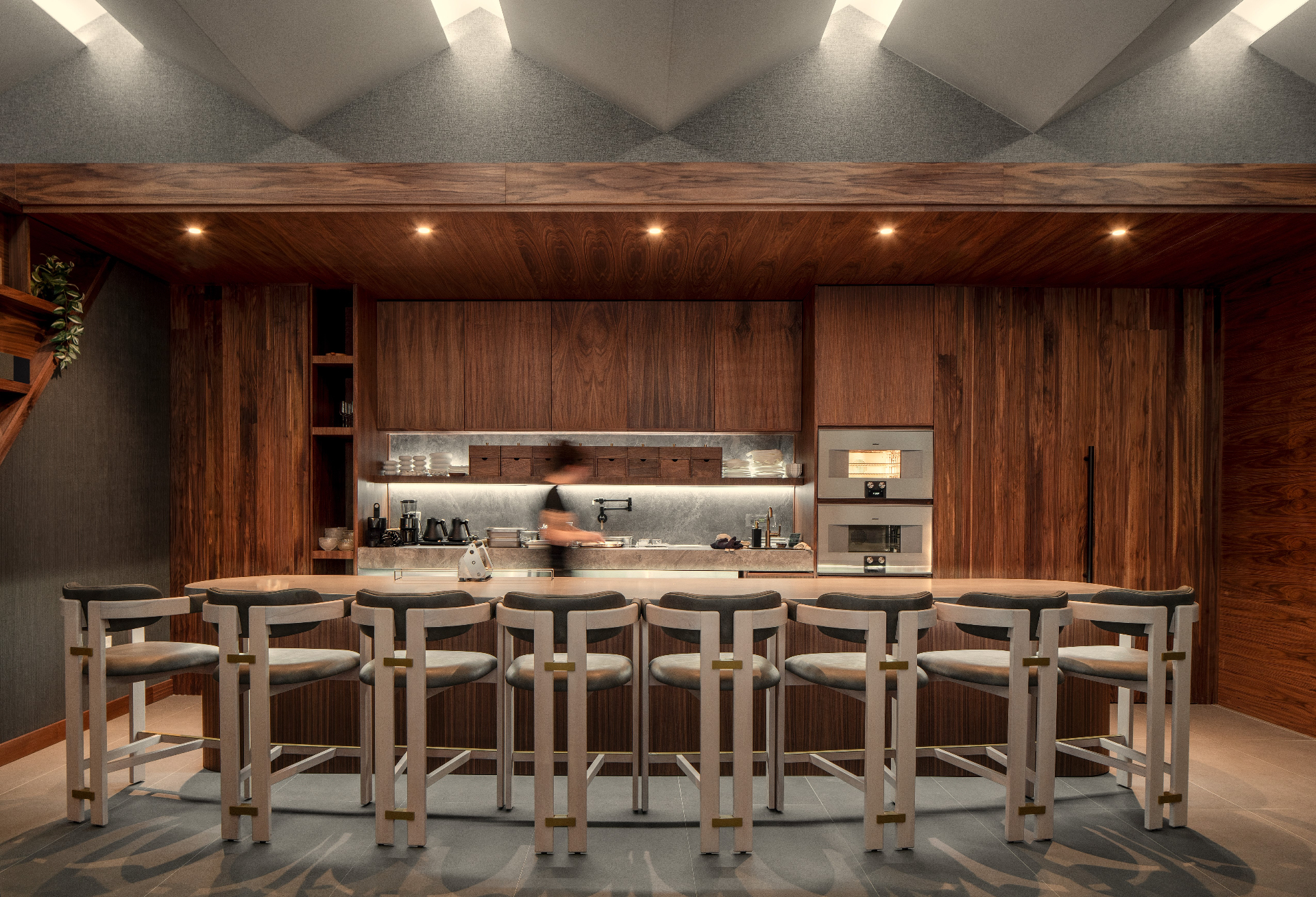 Warm chef's-counter dining room with walnut millwork and sculptural ceiling lights